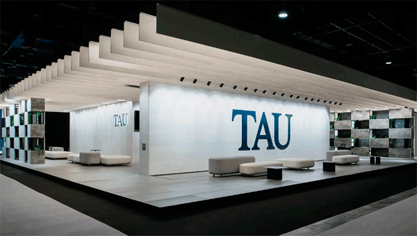 Stand de TAU Cerámica con varios asientos blancos y el logo corporativo