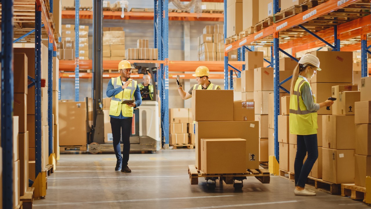 Varios operarios transportan cajas de mercancías en un almacén de logística