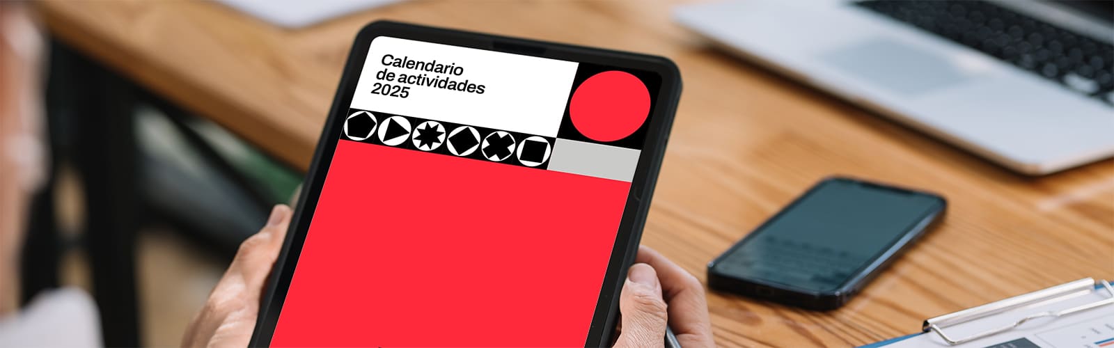 Una persona sujeta una tablet donde visualiza la portada del calendario de Audiovisual from Spain 2025