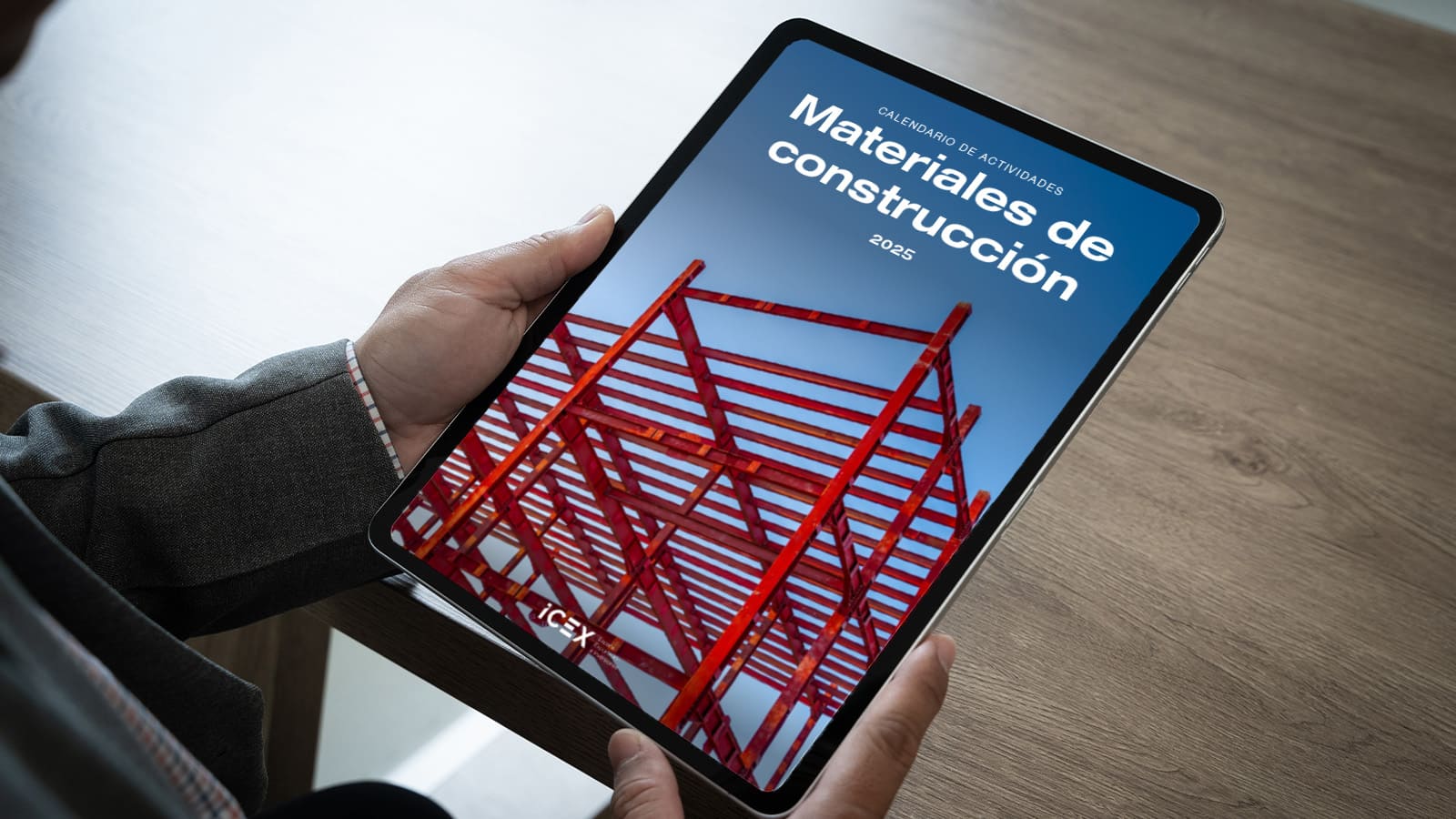 Un hombre pulsa la pantalla de una tablet donde se visualiza el calendario de actividades de materiales de construcción