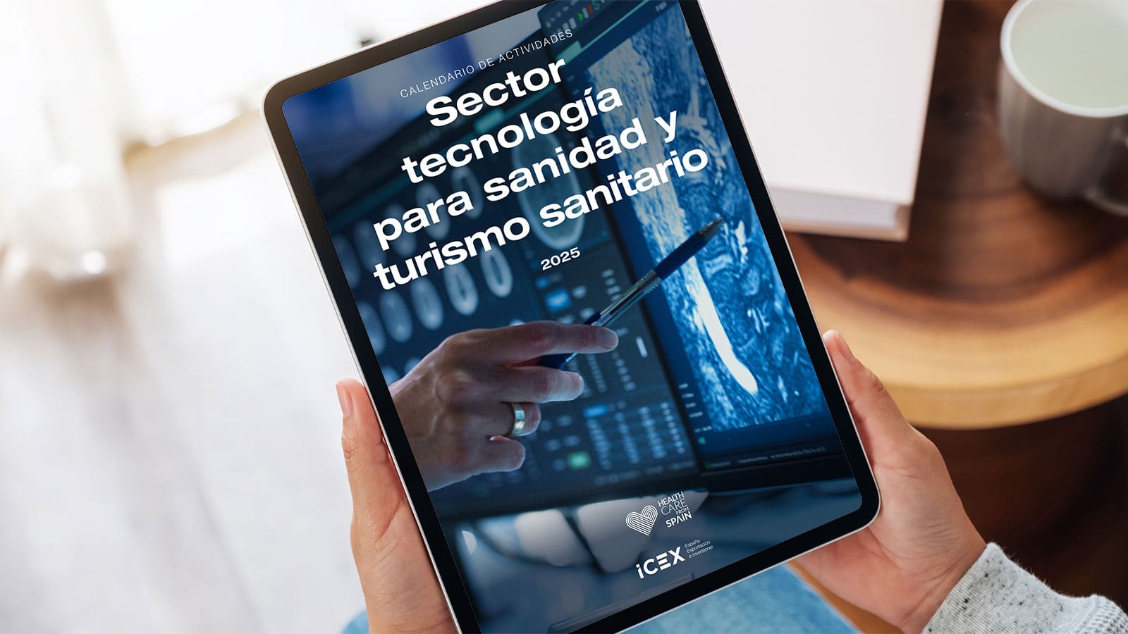 Una persona sostiene una tablet donde visualiza el calendario ICEX para el sector de tecnología sanitaria 2025