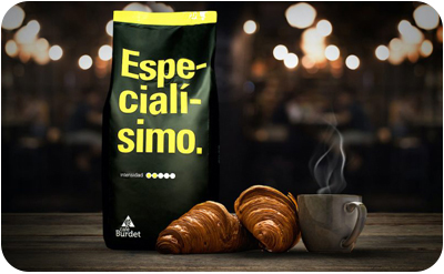 Bolsa de café, cruasanes y taza sobre fondo oscuro