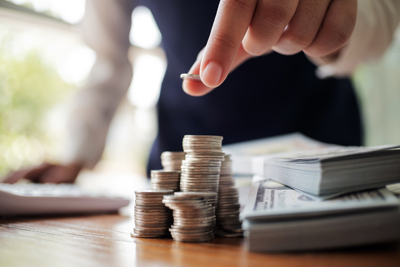 Mano apilando monedas sobre una mesa