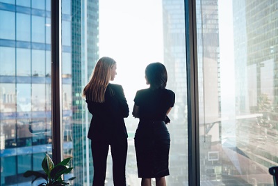 dos mujeres hablan de negocios de espaldas a la cámara