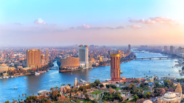 Vista de El Cairo atravesado por el Nilo y con edificios de oficinas al atardecer