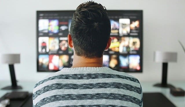 Un hombre de espalda mirando distintas pantallas