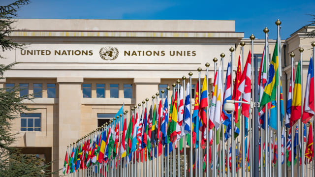 Edificio de Naciones Unidas con las banderas de todos los países en el lateral en primer plano