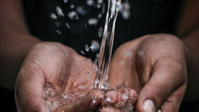 Plano detalle de unas manos recogiendo agua