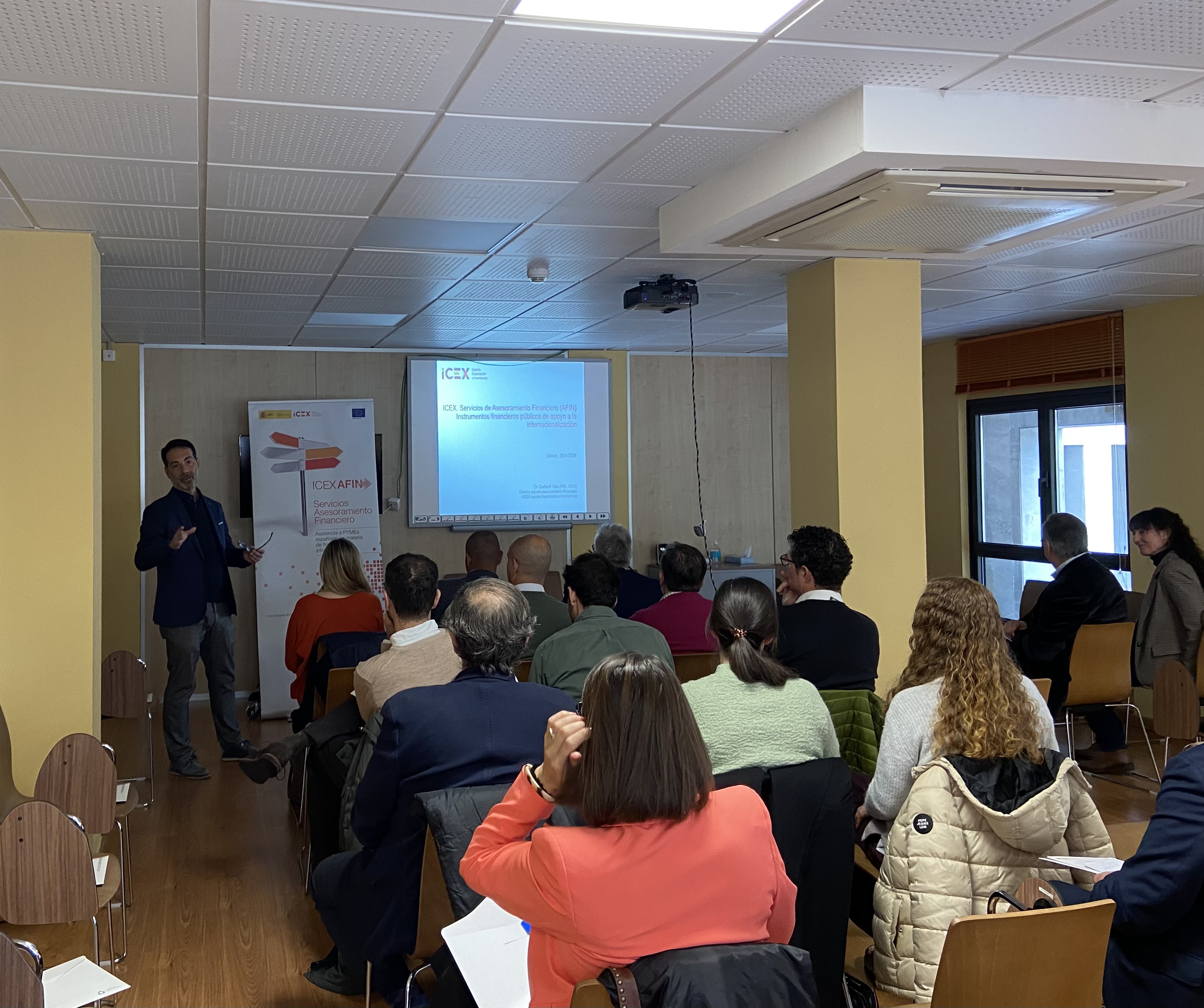 Grupo de personas sentadas escuchando una conferencia sobre ayudas públicas para empresas españolas