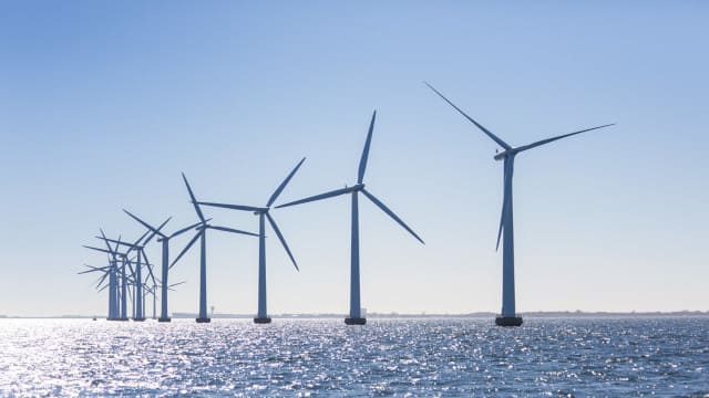 Parque eólico marino con varios molinos de viento sobre el mar