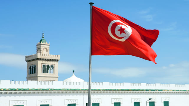 Plaza del ayuntamiento de Túnez con la bandera nacional ondeando en primer plano