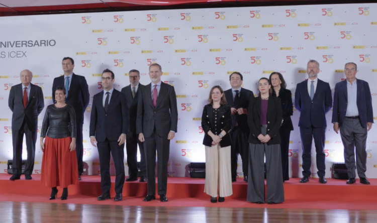 personas en dos filas sobre un fondo blanco con el logo del 50 aniversario de las Becas ICEX