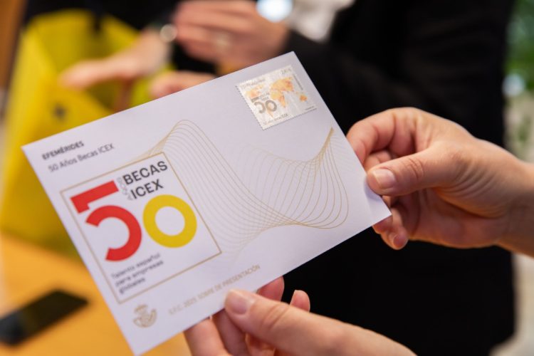 manos sujetando postal con sello 50 aniversario Becas ICEX