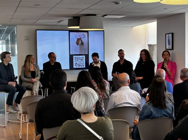 Una persona realiza una presentación ante varios profesionales, en una sala de reuniones dentro de Boutique Design.