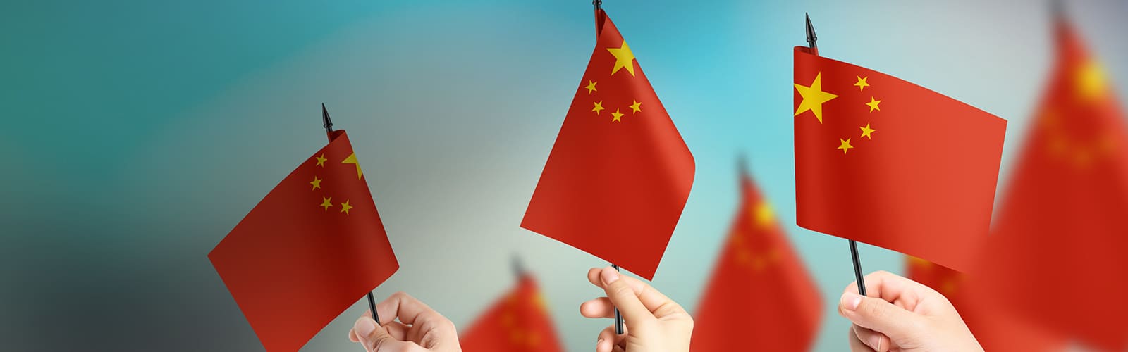 Varias manos hondean banderas de China.