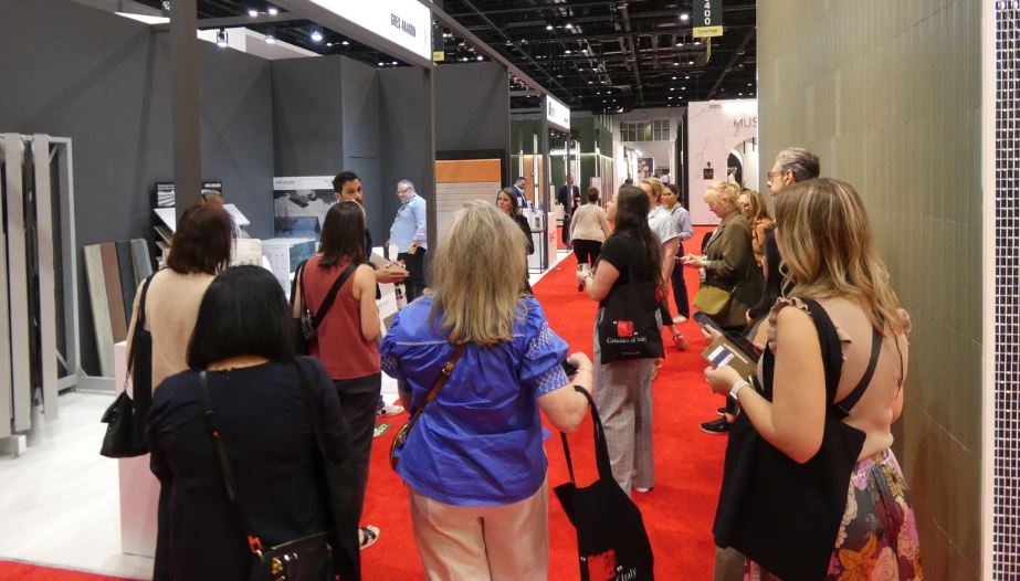 Varias mujeres visitan un stand en el que se exponen muestras de pavimentos, dentro del Pabellón España de Coverings.