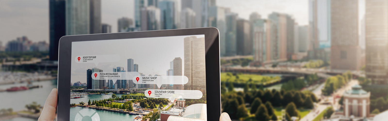 Una persona enfoca el paisaje de una ciudad con jardines y rascacielos con la cámara de su tablet, y en la tablet se visualizan enlaces con las ubicaciones de mayor interés turístico.