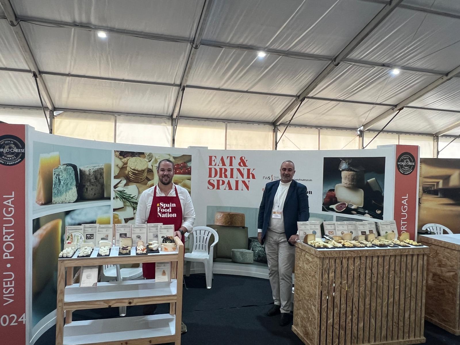 Dos personas mostrando sus quesos españoles en el espacio en el stand institucional de #Spain Food Nation de cata libre