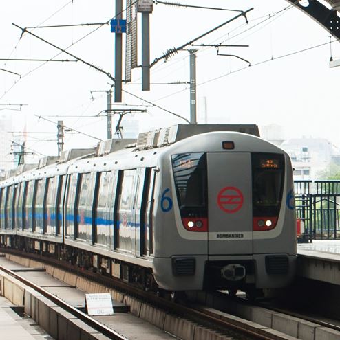 Un tren con carrocería gris y azul llega a una estación.