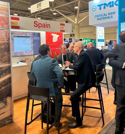 Varias personas conversan en dos mesas de reuniones del Pabellón España de PDAC Canadá.