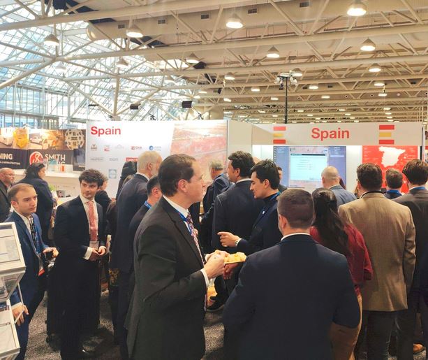 Varios visitantes profesionales se congregan alrededor del Pabellón España de PDAC Canadá.
