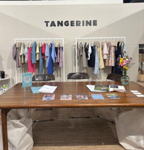 Un stand con un showroom de prendas de vestir, calzado y complementos de moda infantil, dentro de Playtime II París.