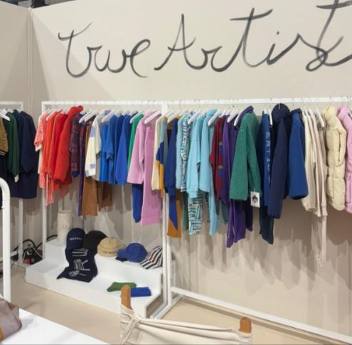 Un stand con un showroom de prendas de vestir, calzado y complementos de moda infantil, dentro de Playtime II París.