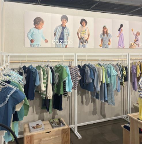 Un stand con un showroom de prendas de vestir, calzado y complementos de moda infantil, dentro de Playtime II París.