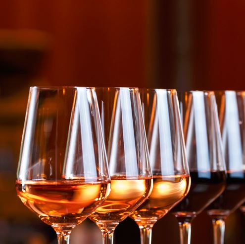 Una fila de copas de vino blanco y tinto.