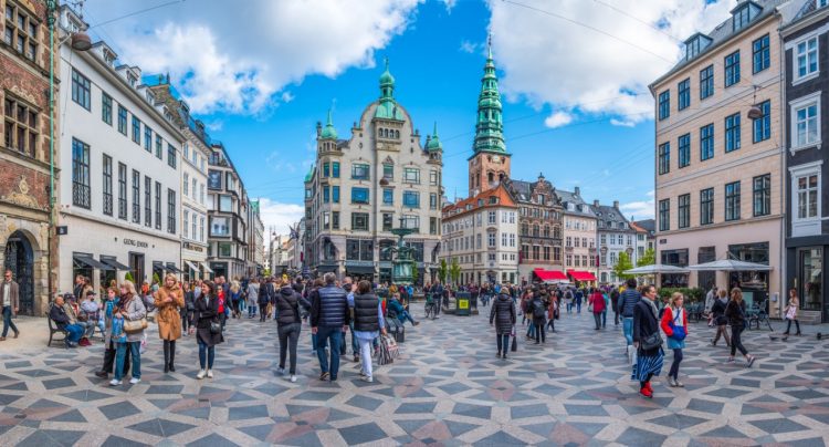 Crowds of shoppers and tourists enjoying the sunshine in the pretty Gammeltorv and Nytorv squares on the Stroget shopping district in the heart of Copenhagen, Denmarkâ  s vibrant capital city.