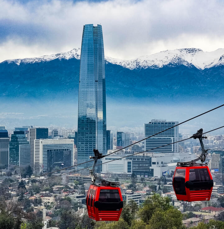 Vista de Santiago de Chile con el Costanera Center, teleférico rojo en primer plano y la Cordillera de los Andes nevada