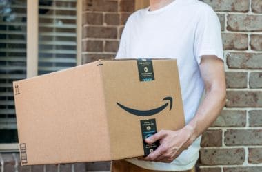 Imagen ilustrativa para la noticia de cómo identificar un catálogo ganador para vender en Amazon fuera de España. Presenta un hombre con una caja de Amazon.