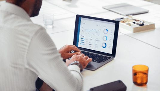 Hombre ante un ordenador que muestra gráficos