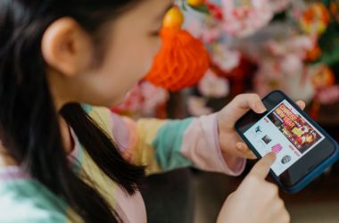 Imagen ilustrativa para la noticia de JD.com llegando a Europa. Muestra una joven realizando compras online en su teléfono móvil.