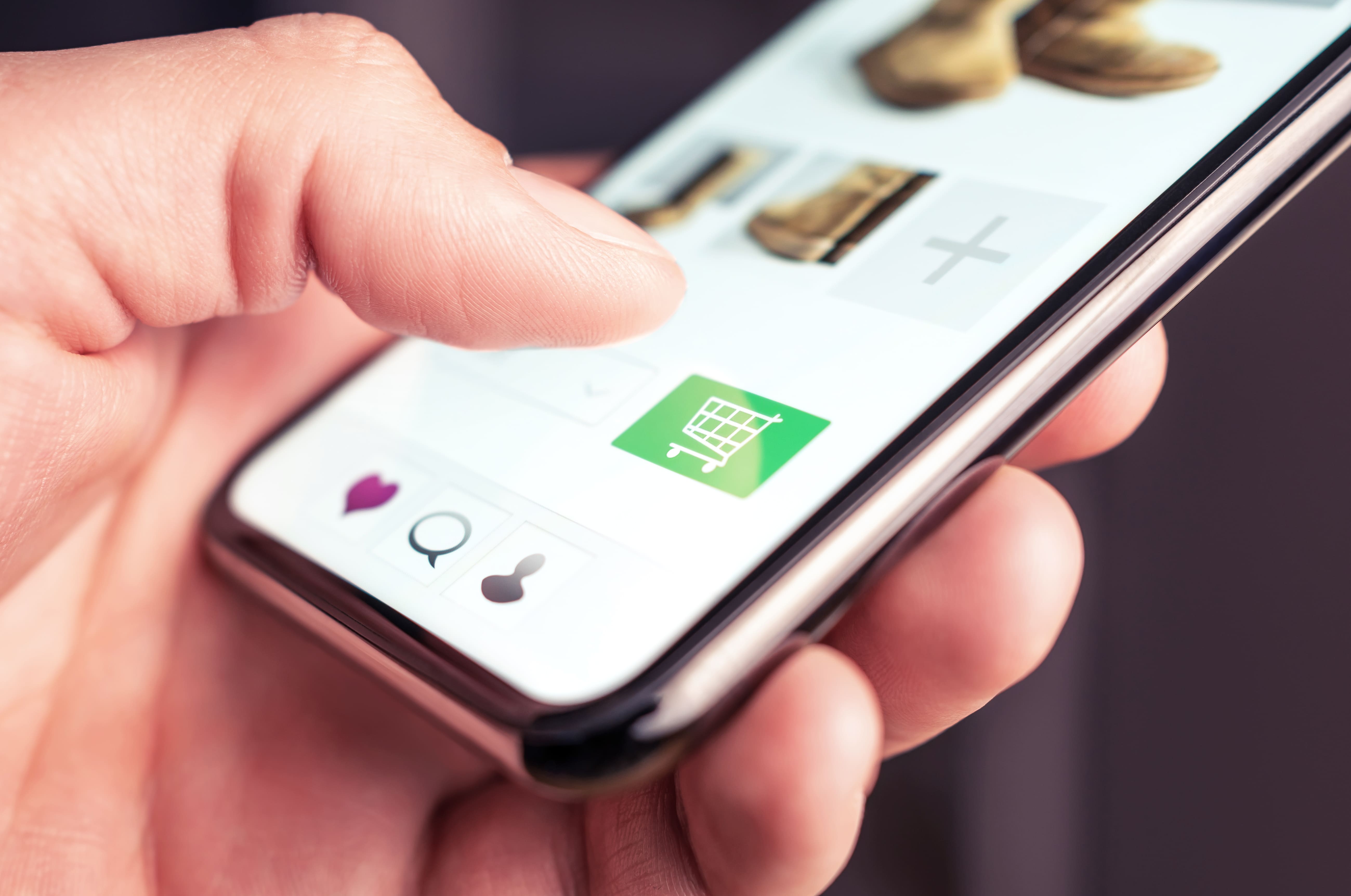 Imagen ilustrativa de la noticia "Niceshops alcanza un récord histórico en 2025: crecimiento del 20 % y expansión internacional". Muestra una mano realizando una compra online en un teléfono móvil.