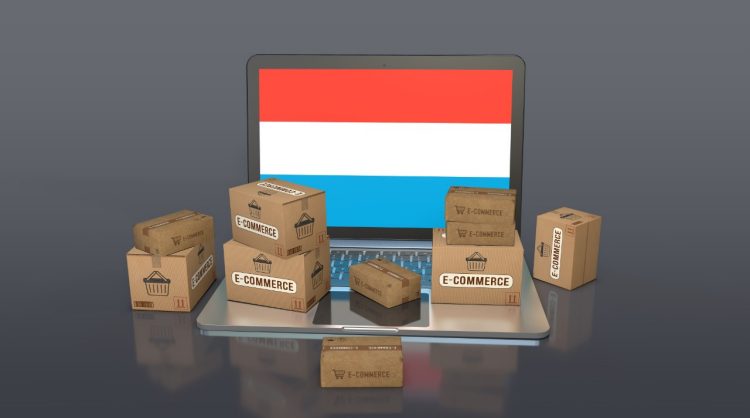 Imagen ilustrativa de la noticia "Luxemburgo lidera el eCommerce transfronterizo en Europa: el 80% de las compras online se realizan en tiendas extranjeras". Muestra varias cajas de envíos junto a un ordenador portátil con la bandera de Luxemburgo.