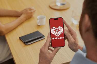 Un consumidor online de Pinuoduo sostiene un smartphone