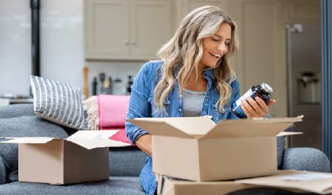 Mujer mirando un producto sacado de una caja
