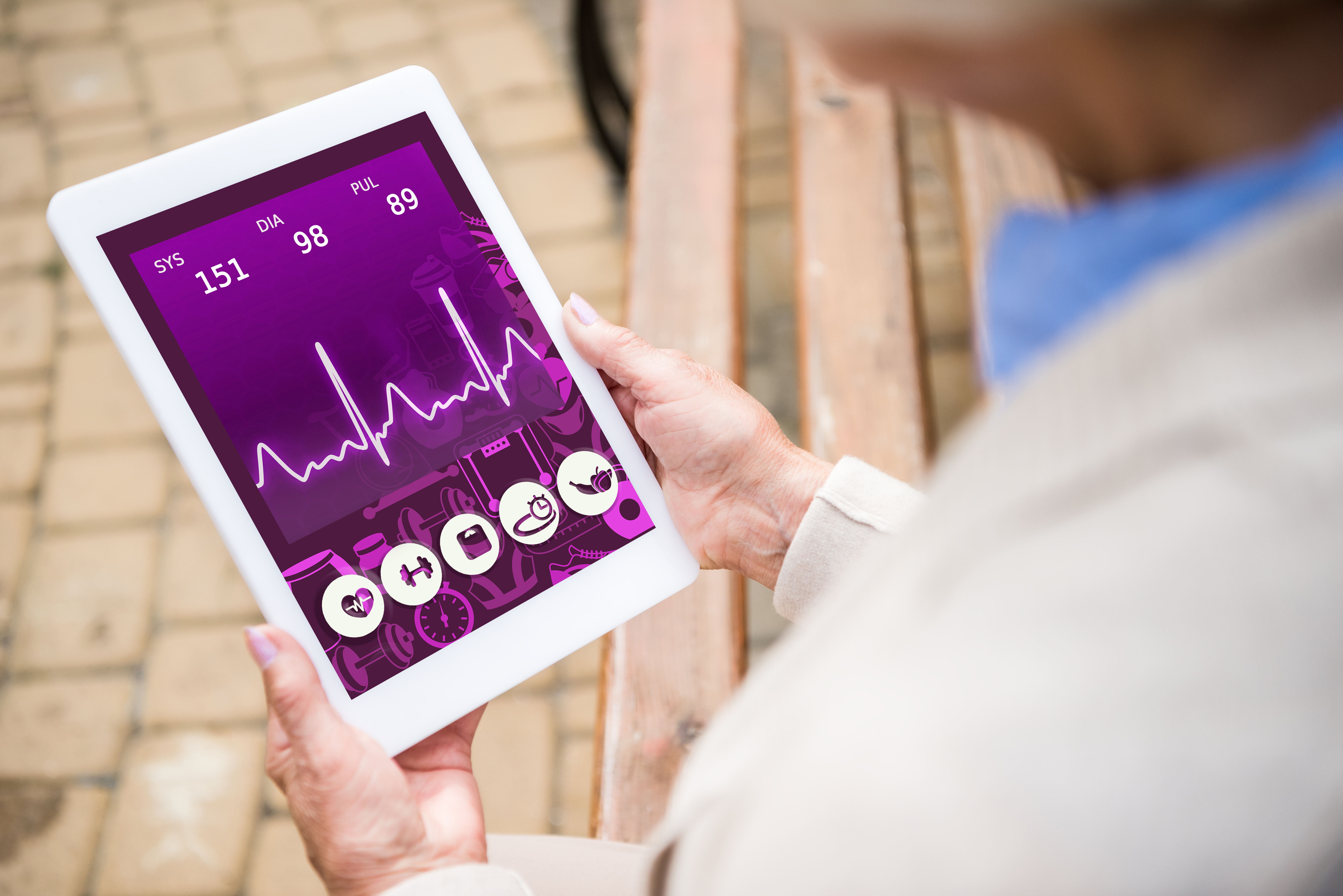  senior woman holding digital tablet with heartbeat rate on screen