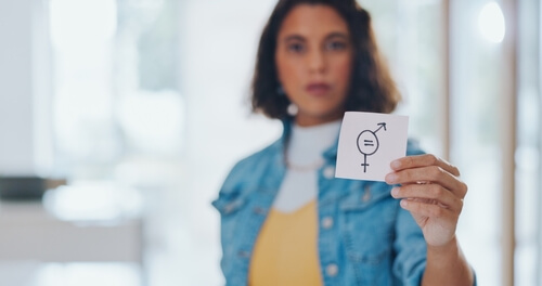 Mujer sujetando papel con símbolo sobre igualdad de género