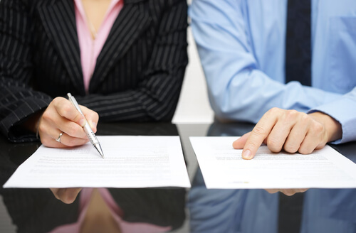 Mujer y hombre directivos revisando un contrato