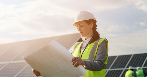 mujer trabajando en la construcción con un plano en las manos