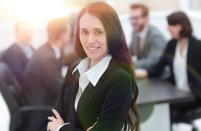 fotografía de una mujer con reunión de trabajo a su espalda