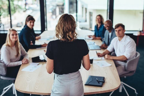 Mujer dirigiendo la reunión de su equipo