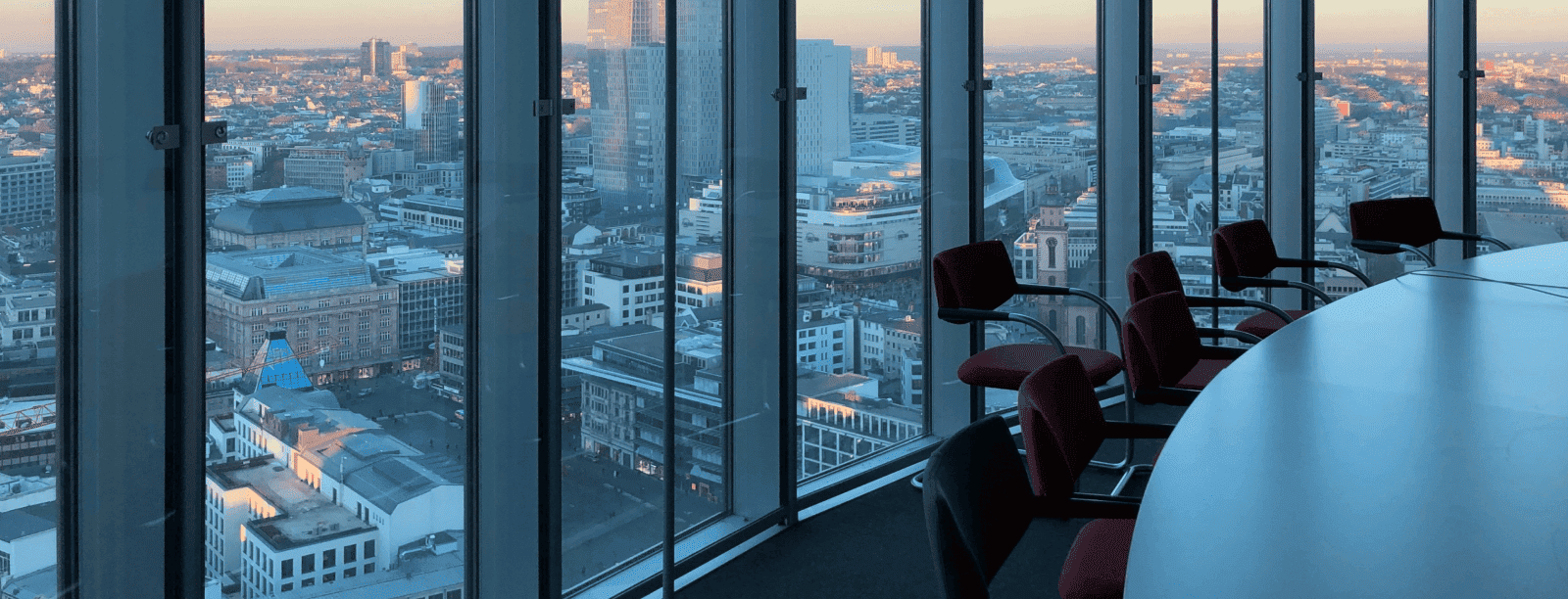 Mesa de conferencias frente a una gran ventana con vista panorámica de la ciudad