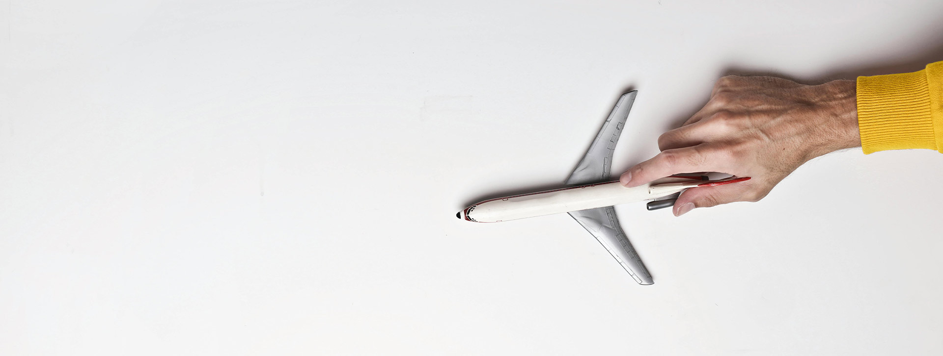 Una mano sujeta un avión blanco en miniatura