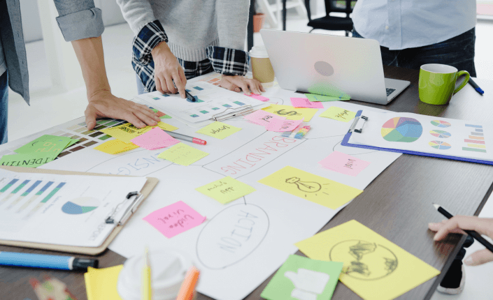 Personas de negocios colaborando en un proyecto, intercambiando ideas y trabajando en equipo para alcanzar objetivos comunes