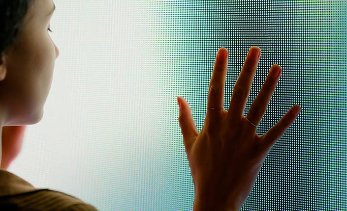 persona apoyando mano sobre pantalla verde transparente