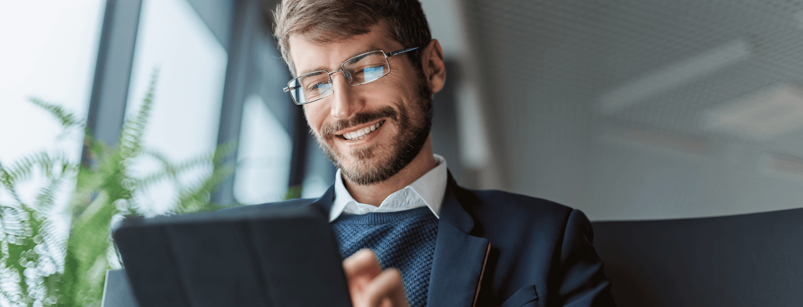Hombre con gafas y barba utilizando una tableta