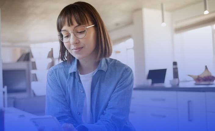 Mujer con gafas mirando un dispositivo electrónico